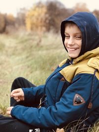 Boy squatted in a field to rest