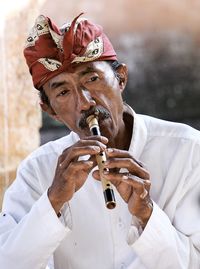 Portrait of man holding balinese flutes