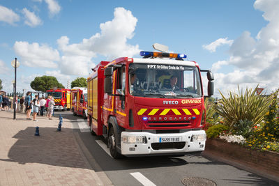 Vehicles on road against sky in city