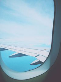 Close-up of airplane wing against sky