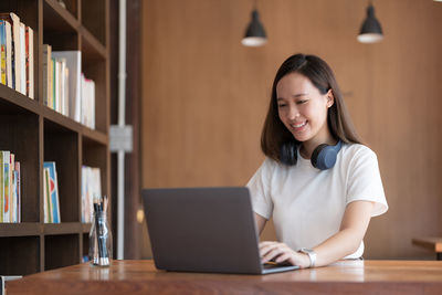 Young woman using laptop at table