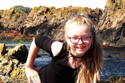 Portrait of smiling young woman standing by lake