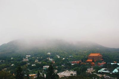 View of cityscape against cloudy sky