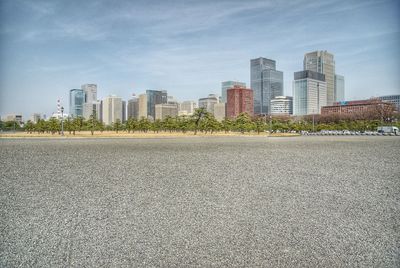 Surface level of road by buildings against sky