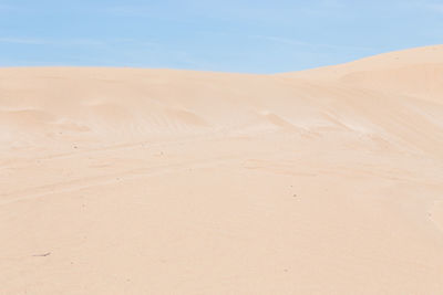 Sand dunes in desert against sky