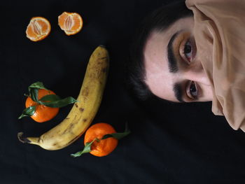 Portrait of woman with orange fruits