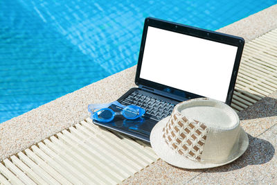 Low angle view of smart phone by swimming pool