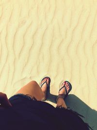 Low section of woman standing at beach