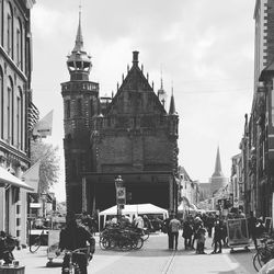 People on street amidst buildings in city