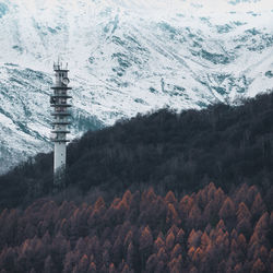 Tower against snow covered mountains