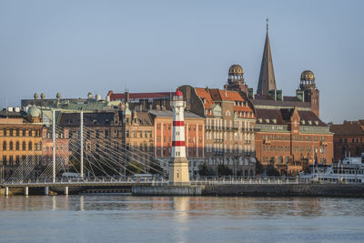 Sweden, skane county, malmo, harbor lighthouse with bridge and danske bank in background