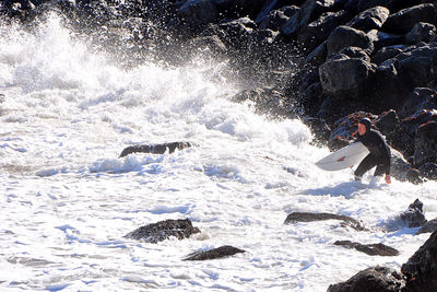 People on rock in sea