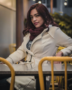 Portrait of woman sitting in snow