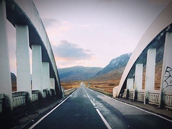 Road by mountain against sky