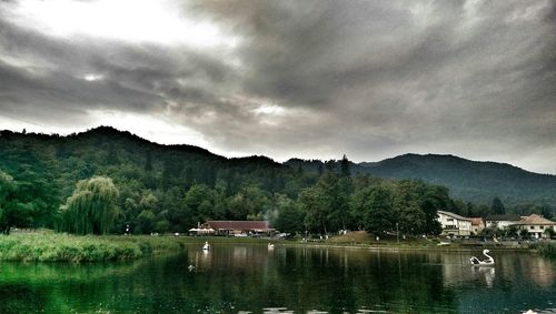 Scenic view of river and mountains against cloudy sky