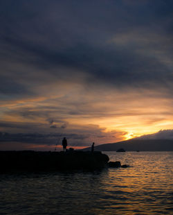 Silhouette people in sea against sky during sunset, lahaina, hawaii