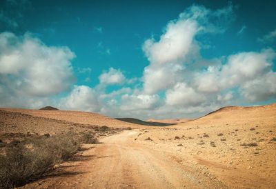 Panoramic view of dirt road against sky