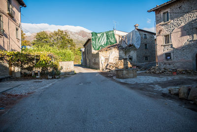 Street amidst buildings in town against sky