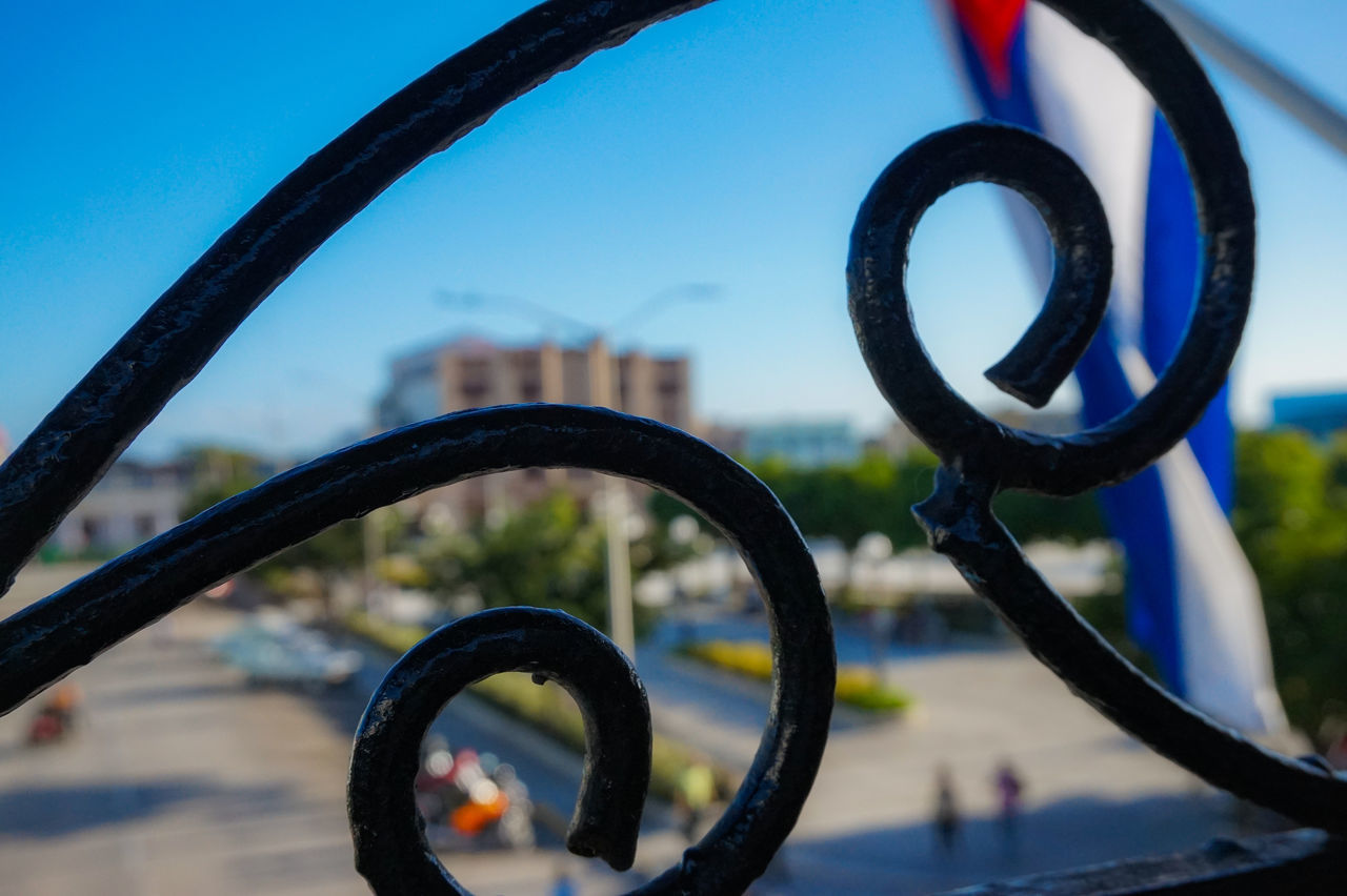 CLOSE-UP OF METAL WHEEL AGAINST SKY