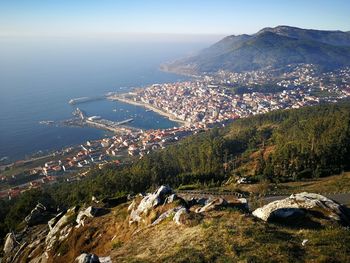 High angle view of sea by mountains against sky