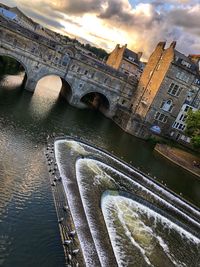 Aerial view of bridge over river in city against sky