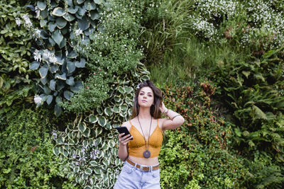 Portrait of woman standing against plants