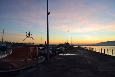 Street by road against sky during sunset