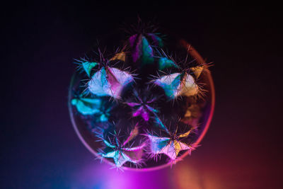 Close-up of illuminated lighting equipment against black background