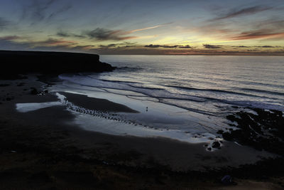 View of calm beach at sunset