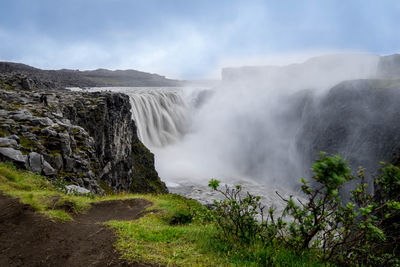 Scenic view of waterfall against sky