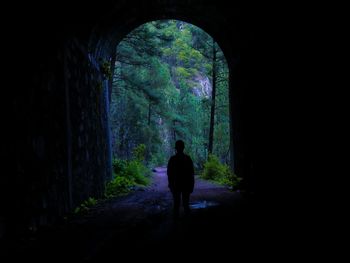 Silhouette man walking in tunnel