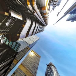 Directly below shot of modern buildings against sky in city