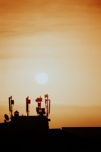 Silhouette crane against sky during sunset