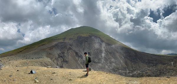 Rear view of man on arid landscape against sky