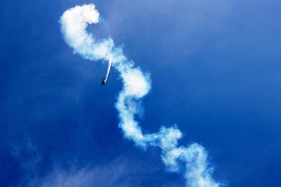 Low angle view of airplane flying against blue sky