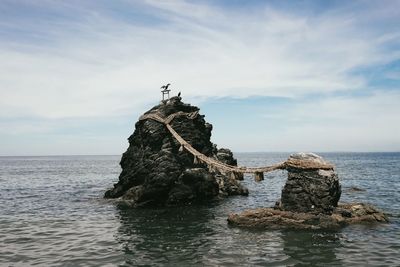 Meoto iwa against cloudy sky