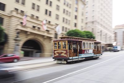 Train on road in city against sky