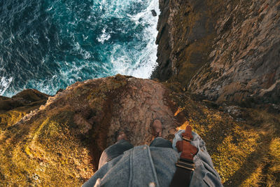 People on rock by sea