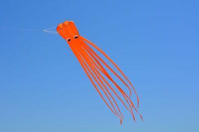 Low angle view of kite flying against clear blue sky