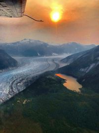 Aerial view of snowcapped mountains against sky during sunset