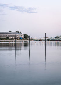 Scenic view of lake against sky in city