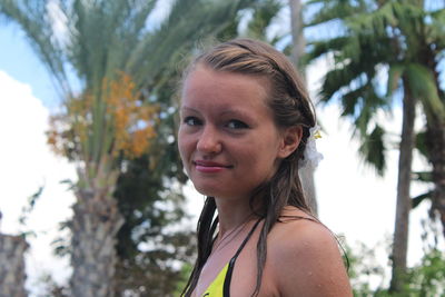 Portrait of smiling young woman against plants