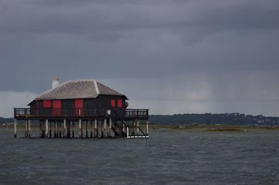 Built structures in water against cloudy sky