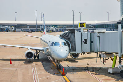 Airplane on airport runway against sky