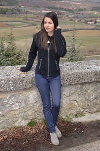 Full length of young woman looking away while standing on observation point