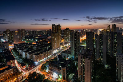 High angle view of illuminated cityscape against sky at night