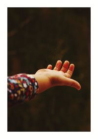 Close-up of woman hand against black background