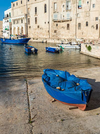 Boats moored in canal by buildings in city