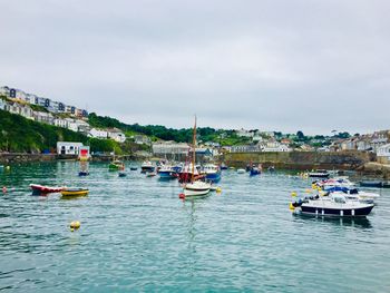 Sailboats moored in sea against sky