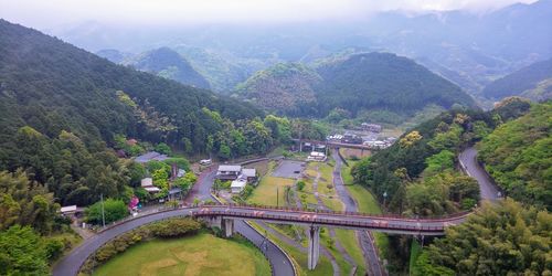 High angle view of road amidst trees against mountains